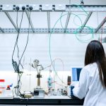 Pesquisadora realiza experimentos em um laboratório moderno equipado para pesquisa científica.