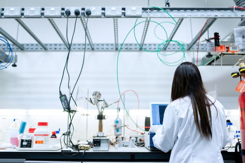Pesquisadora realiza experimentos em um laboratório moderno equipado para pesquisa científica.