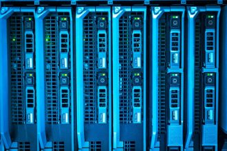 Rack de servidores iluminado em azul em um ambiente moderno de infraestrutura tecnológica.
